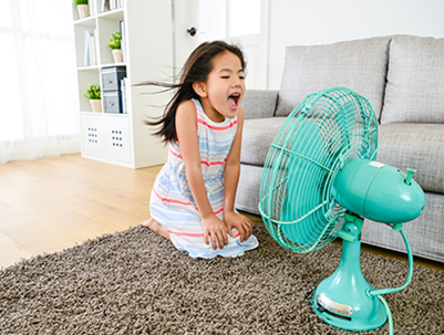 little girl in front of a small fan